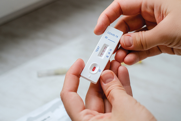 Two hands hold a COVID-19 test.